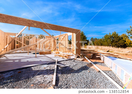 Wooden beams framing at construction site with building materials scattered around during framework Wooden beams framing at construction site with building materials scattered around during framework 138512854