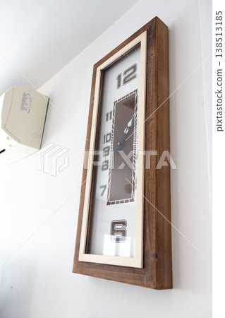 A large clock mounted on a white wall A large clock mounted on a white wall 138513185