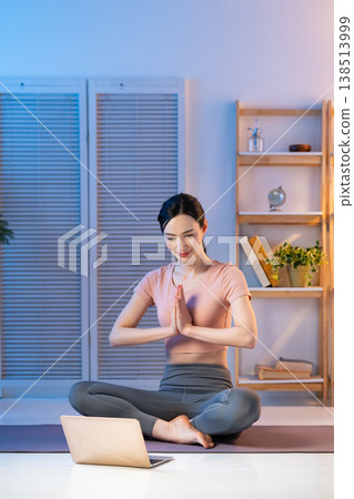 A woman stretching while looking at a computer A woman stretching while looking at a computer 138513999