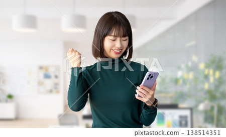 A woman/businesswoman happy to see her smartphone A woman/businesswoman happy to see her smartphone 138514351