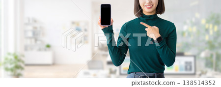 Woman/businesswoman pointing at smartphone 138514352