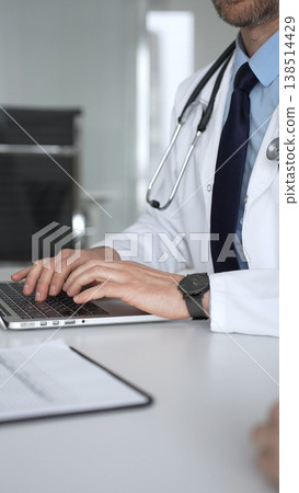 Medical professional typing on laptop, reviewing patient data, consulting online, using telehealth technology. Medicine, healthcare and science concept Medical professional typing on laptop, reviewing patient data, consulting online, using telehealth technology. Medicine, healthcare and science concept 138514429