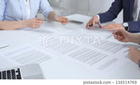 Business partners discussing contract terms, reviewing legal documents during an office meeting, focusing on agreement details and professional negotiation strategies Business partners discussing contract terms, reviewing legal documents during an office meeting, focusing on agreement details and professional negotiation strategies 138514769