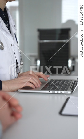 Doctor woman consulting male patient using laptop, discussing health information during medical examination at clinic office. Medicine, healthcare and science concept 138514780