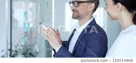 Business colleagues collaborating on a strategic project, discussing creative ideas and planning solutions, showing teamwork and problem solving skills in a modern office environment 138514808