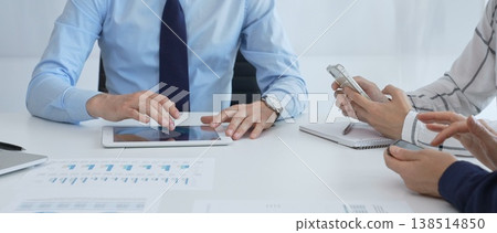 Business team working together, analyzing financial charts and data on digital tablet and smartphones, during a productive meeting in a modern office Business team working together, analyzing financial charts and data on digital tablet and smartphones, during a productive meeting in a modern office 138514850