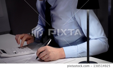 Professional businessman analyzing financial data and statistics, calculating costs, making important budget reports at office desk. Audit and taxes theme in business Professional businessman analyzing financial data and statistics, calculating costs, making important budget reports at office desk. Audit and taxes theme in business 138514925