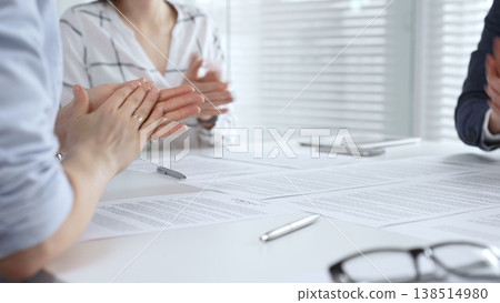 Business executives shaking hands, sealing an agreement after successful negotiations in a bright office, symbolizing partnership, collaboration, and a mutually beneficial deal signing 138514980