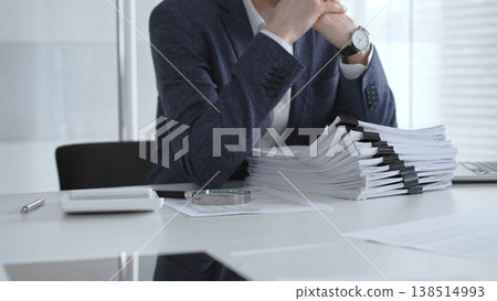 Business person analyzing financial documents with a magnifying glass, conducting an audit, reviewing reports, and investigating data on an office desk at work. Audit and taxes Business person analyzing financial documents with a magnifying glass, conducting an audit, reviewing reports, and investigating data on an office desk at work. Audit and taxes 138514993