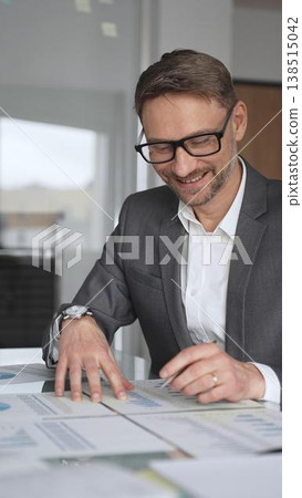 Business professional analyzing financial data with charts and graphs, discussing market trends, planning strategy, collaborating on corporate project in modern office, vertical view Business professional analyzing financial data with charts and graphs, discussing market trends, planning strategy, collaborating on corporate project in modern office, vertical view 138515042