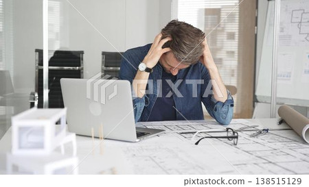 Stressed architect feeling overwhelmed and frustrated, suffering from burnout while working on blueprints for a tight project deadline in a modern office setup Stressed architect feeling overwhelmed and frustrated, suffering from burnout while working on blueprints for a tight project deadline in a modern office setup 138515129