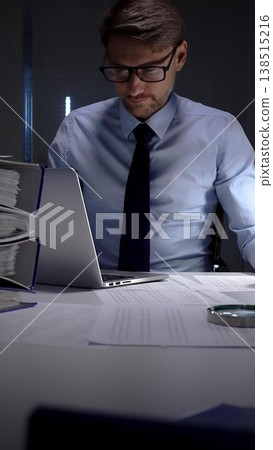 Businessman working overtime in office signing document at night, preparing contracts and finances. Audit and taxes in business Businessman working overtime in office signing document at night, preparing contracts and finances. Audit and taxes in business 138515216