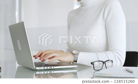 Woman working remotely, typing on laptop at home office desk, focusing on online business and communication Woman working remotely, typing on laptop at home office desk, focusing on online business and communication 138515260
