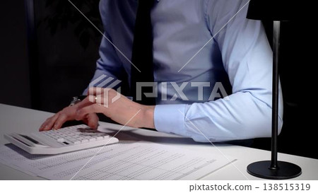 Professional businessman analyzing financial data and statistics, calculating costs, making important budget reports at office desk. Audit and taxes theme in business Professional businessman analyzing financial data and statistics, calculating costs, making important budget reports at office desk. Audit and taxes theme in business 138515319
