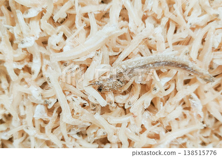 Dried Small Fish Spread on Light Wooden Surface in Natural Daylight 138515776