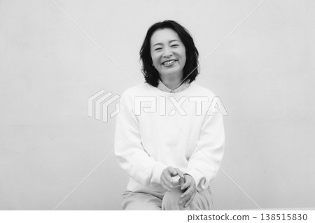 一張黑白肖像照，照片中的是我童年故居裡笑容燦爛的母親。 138515830