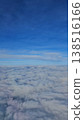 Vertical aerial view of a fluffy white cloudscape stretching to the horizon under a bright blue sky, captured from a flight over the Andaman Sea. 138516166