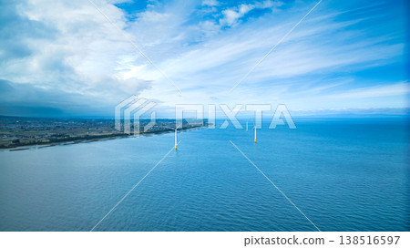 A view from the mouth of a small stream in eastern Toyama Prefecture in early spring, showing the Northern Alps and offshore wind turbines hidden by clouds. A view from the mouth of a small stream in eastern Toyama Prefecture in early spring, showing the Northern Alps and offshore wind turbines hidden by clouds. 138516597