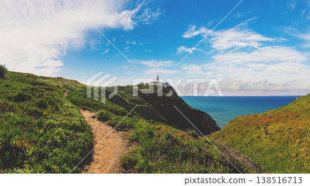 Panoramic view of the Cape Roca (Cabo da Roca) shore on a sunny day. Lighthouse on the top of the rock. Rocky seascape. Assentiz Beach. Region of Cape Roca, Atlantic Ocean, Portugal 138516713