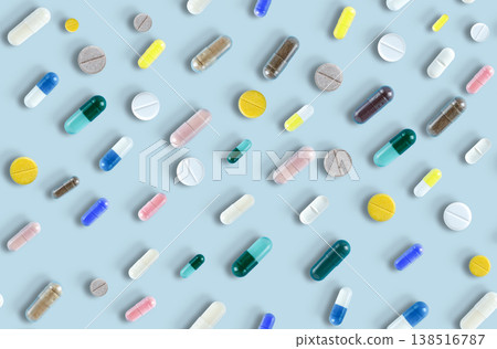 Colorful medicine tablets antibiotic pills on soft blue background. Colorful pills and capsules. Minimal medical concept. Pharmaceutical, Covid-19 or Coronavirus. Flat lay, top view Colorful medicine tablets antibiotic pills on soft blue background. Colorful pills and capsules. Minimal medical concept. Pharmaceutical, Covid-19 or Coronavirus. Flat lay, top view 138516787