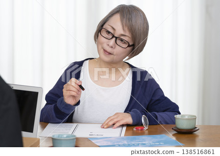 一位老年婦女簽署並蓋章了一份人壽保險契約。 138516861