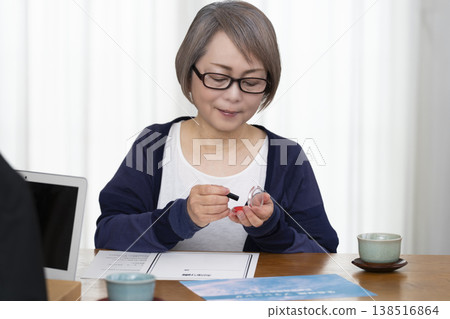 A senior woman signs and seals a life insurance contract. A senior woman signs and seals a life insurance contract. 138516864