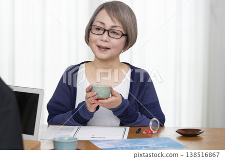 A senior woman signs and seals a life insurance contract. A senior woman signs and seals a life insurance contract. 138516867