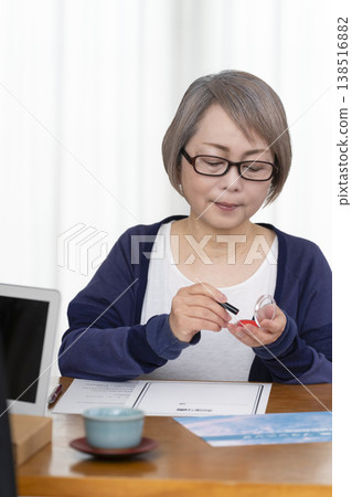 A senior woman signs and seals a life insurance contract. 138516882