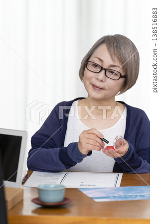 一位老年婦女簽署並蓋章了一份人壽保險契約。 一位老年婦女簽署並蓋章了一份人壽保險契約。 138516883