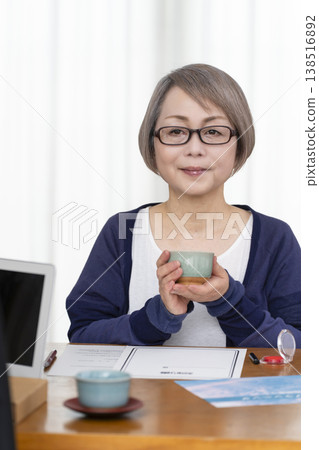 A senior woman signs and seals a life insurance contract. 138516892