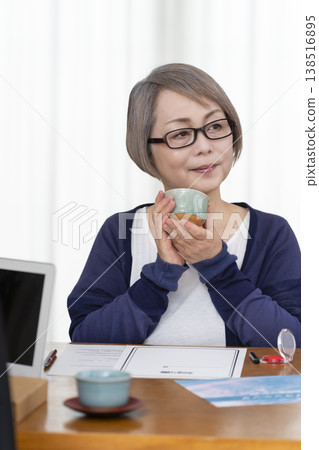 一位老年婦女簽署並蓋章了一份人壽保險契約。 一位老年婦女簽署並蓋章了一份人壽保險契約。 138516895
