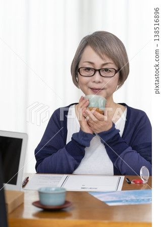 一位老年婦女簽署並蓋章了一份人壽保險契約。 一位老年婦女簽署並蓋章了一份人壽保險契約。 138516896