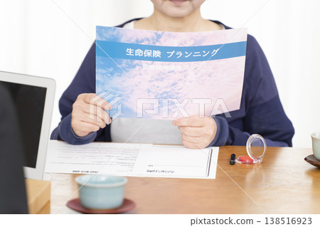 老婦人在簽署人壽保險合約時的手。 老婦人在簽署人壽保險合約時的手。 138516923