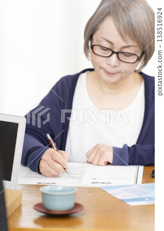 老婦人在簽署人壽保險合約時的手。 老婦人在簽署人壽保險合約時的手。 138516924