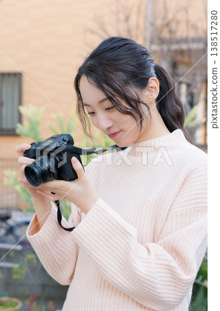 一幅母女關係親密的肖像畫,女兒正在陽台上為母親拍照。 一幅母女關係親密的肖像畫,女兒正在陽台上為母親拍照。 138517280