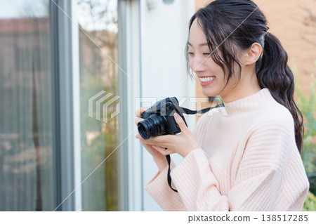 A portrait of a close mother and daughter taking a picture of the mother on the veranda. A portrait of a close mother and daughter taking a picture of the mother on the veranda. 138517285