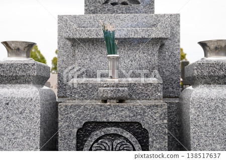 A tombstone, incense sticks, and smoke from the incense sticks. A tombstone, incense sticks, and smoke from the incense sticks. 138517637