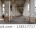 A view of a parking lot under a railway overpass. 138517717