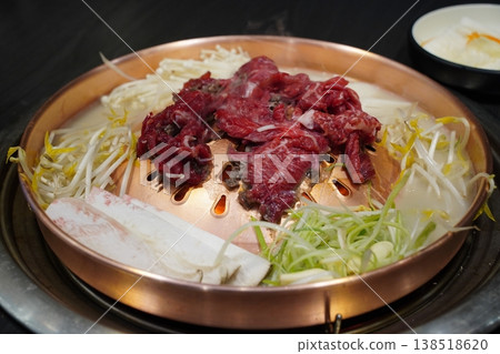 Fresh raw Hanwoo beef bulgogi with vegetables on a traditional Korean copper grill Fresh raw Hanwoo beef bulgogi with vegetables on a traditional Korean copper grill 138518620