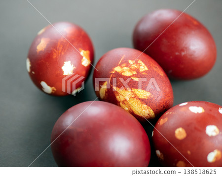 Hand-dyed Easter eggs with traditional natural patterns. Deep red and maroon tones highlight leaf motifs for a rustic holiday look Hand-dyed Easter eggs with traditional natural patterns. Deep red and maroon tones highlight leaf motifs for a rustic holiday look 138518625