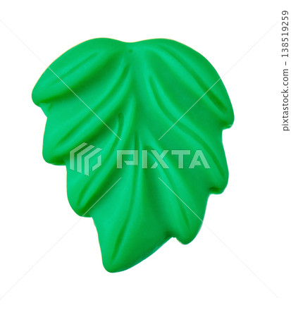 Bright green plastic leaf pieces cut out against a white background. 138519259