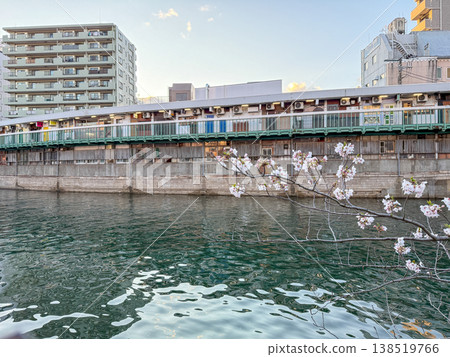 The scene of the Ooka River's surface shimmering in the evening light and the apartment buildings along its banks. April 2026, Yokohama City, Japan. The scene of the Ooka River's surface shimmering in the evening light and the apartment buildings along its banks. April 2026, Yokohama City, Japan. 138519766