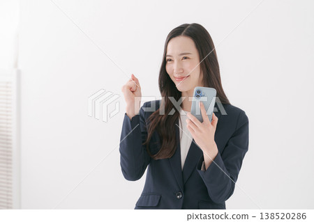 A woman with a suit with a smartphone A woman with a suit with a smartphone 138520286