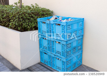 Container boxes for collecting empty cans, stacked next to the building. 138520949