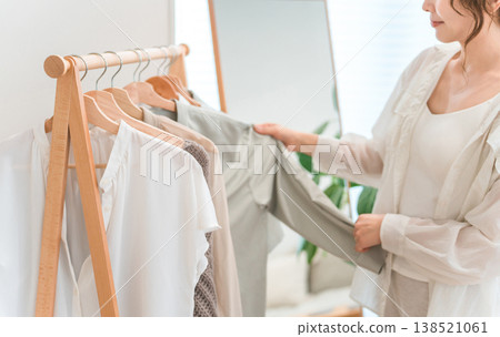 An Asian woman choosing clothes from a clothes rack (shopping, coordinating outfits, sale, shopping) An Asian woman choosing clothes from a clothes rack (shopping, coordinating outfits, sale, shopping) 138521061