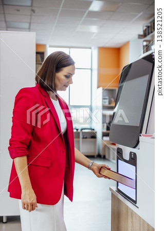 woman returning book at self service library machine looking at camera with confident slight smile in modern library interior professional librarian scene, education, library service 138521205