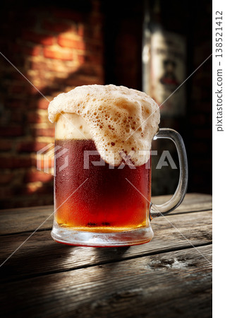 Foamy ruby beer in a pint glass, on a rustic wooden bar background, conveying a concept of refreshment Foamy ruby beer in a pint glass, on a rustic wooden bar background, conveying a concept of refreshment 138521412