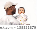 African American father holding beautiful little girl child with finger in mouth in arms Isolated against bright white sky background. Portrait dad with baby 138521879