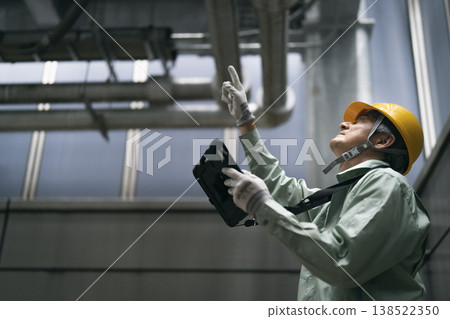A veteran worker inspecting the building's facilities A veteran worker inspecting the building's facilities 138522350