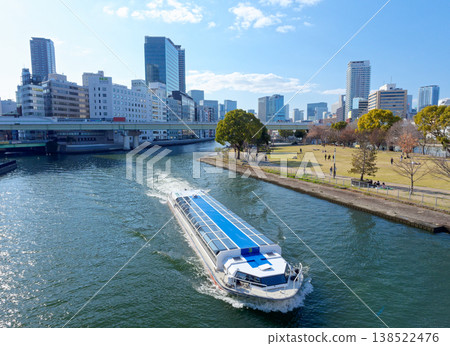 一艘水上巴士正在大阪市中之島公園的草坪區前航行。 一艘水上巴士正在大阪市中之島公園的草坪區前航行。 138522476